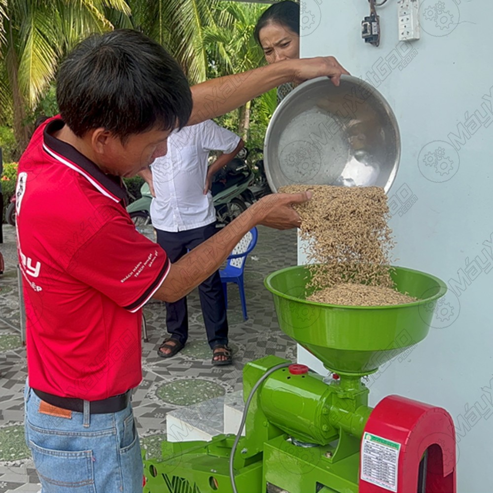 Bỏ thóc vào máy xay xát gạo